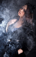 Portrait of a young attractive woman in a puff of smoke