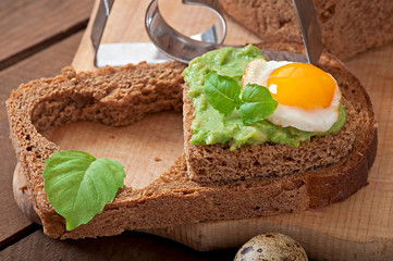 Sandwich with avocado paste and egg in the shape of heart