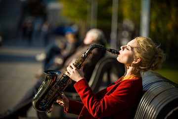 girl with saxofon on street