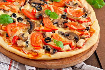 Appetizing pizza with chicken, tomatoes, peppers and mushrooms