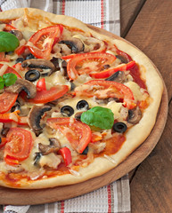 Appetizing pizza with chicken, tomatoes, peppers and mushrooms