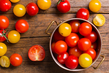 red and yellow cherry tomatoes on wooden background