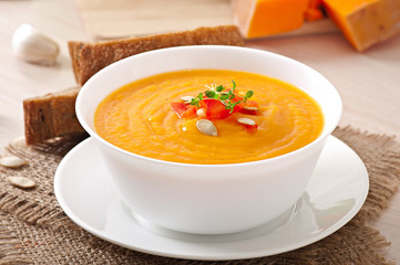 Delicious cream of pumpkin soup in a bowl on wooden table