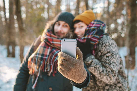 Couple making selfie in winter forest