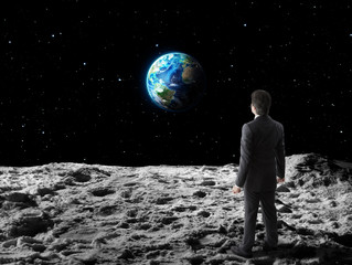 businessman walks  on moon surface - obrazy, fototapety, plakaty