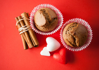 muffin and cinnamon with hearts on red background
