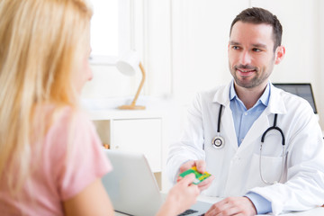 Young attractive doctor taking health insurance card