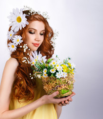 red-haired girl with daisies in hair holding a bouquet
