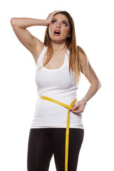 young woman is disappointed by the extent of her waist