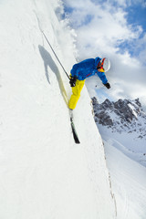 Male skier on downhill freeride with sun and mountain view