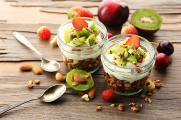 Healthy layered dessert with muesli and fruits on table