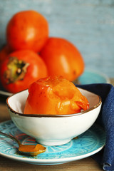 Ripe sweet persimmons, on wooden table