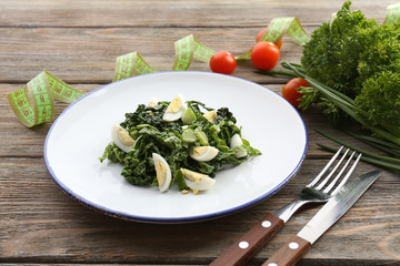 Salad with quail egg and basil in plate with measuring tape