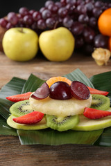Fototapeta na wymiar Fruit dessert on green leaf on table