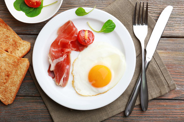 Bacon and eggs on rustic wooden planks background