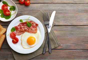 Bacon and eggs on rustic wooden planks background