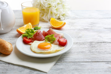 Bacon and eggs on wooden table and white background