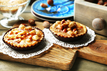 Mini cakes with nuts on wooden background