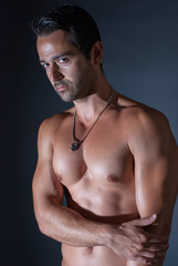 Fototapeta premium Muscle sexy man posing on bark background, showing his muscles