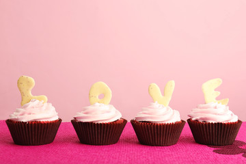 Delicious Valentine Day cupcakes on pink background