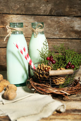 Bottles of fresh milk with natural decor, on wooden background