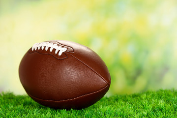 American football on field on green grass, on nature background