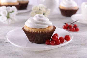Delicious cupcakes on table on light background