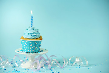 Delicious cupcake on table on blue background