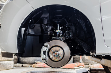 Front disc brake on car in process of new tyre replacement. The