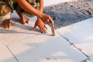 Labor installing tile floor for new house building