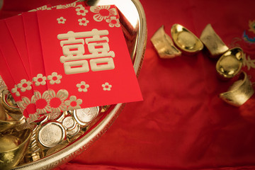Red pocket and ancient Chinese golden ingots on wooden : with co