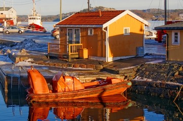 Fototapeta na wymiar Small orange motorboat reflecting in the water