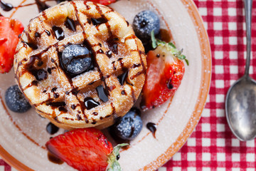 waffles with strawberry ,blueberry poured with chocolate