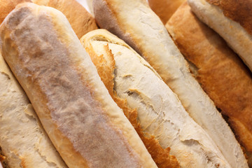 Many white crusty loafs of bread.