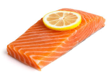 Raw salmon fillet on white. Lemon slice.