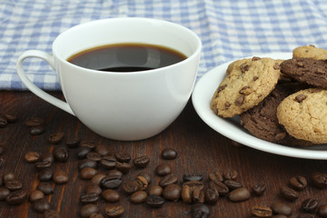 cookies and cup of hot coffee on old wooden table.