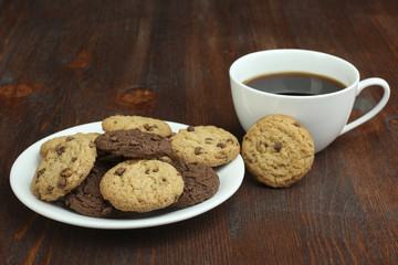 chocolate cookies and cup of hot coffee on old wooden table