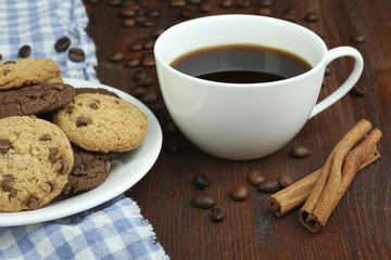chocolate cookies and cup of hot coffee on old wooden table