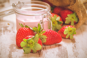Spring fruits, strawberries in a linen sack on a vintage wooden