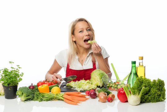 Frau schneidet einen Salatkopf zu und probiert