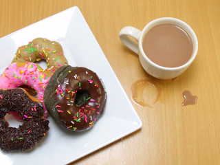 chocolate donuts on a plate on wooden background