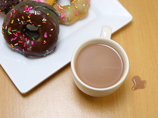 chocolate donuts on a plate on wooden background