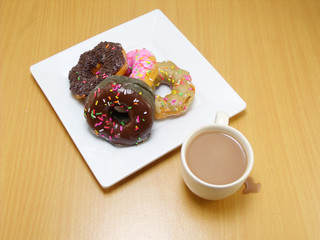 chocolate donuts on a plate on wooden background