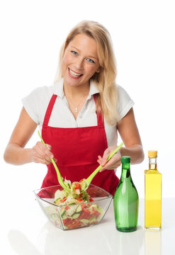 Hausfrau verfeinert Salat mit Essig und Oel