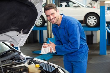 Mechanic examining under hood of car