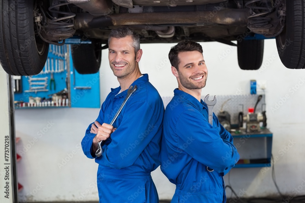 Poster team of mechanics smiling at camera