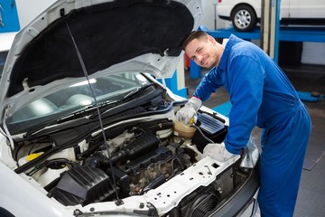 Fototapeta na wymiar Smiling mechanic working on car