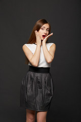 Fototapeta premium Portrait of a pretty young woman putting her hands to her face i