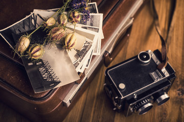 Old photographs, a camera and dried flowers