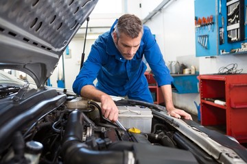 Mechanic examining under hood of car